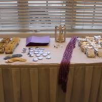 a photo of a table with purple Triota graduation cords, soaps and coffee beans from local vendors, and WGS stickers and buttons